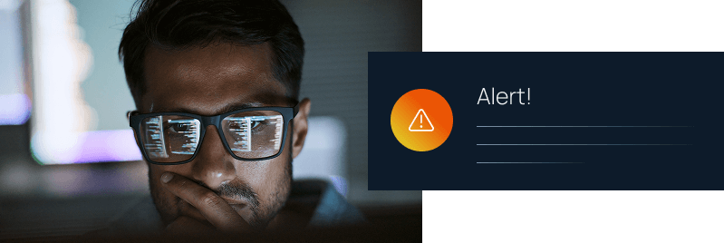 A focused man with code reflected in his glasses stares at a screen beside a dark alert notification with a warning icon.