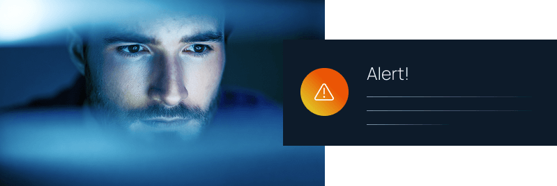 A man's face illuminated by blue screen light beside a dark notification panel with an orange warning icon and "Alert!" text.